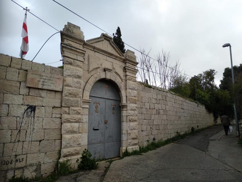 Before: the church gate and its long stone wall on an overcast day, unlit.