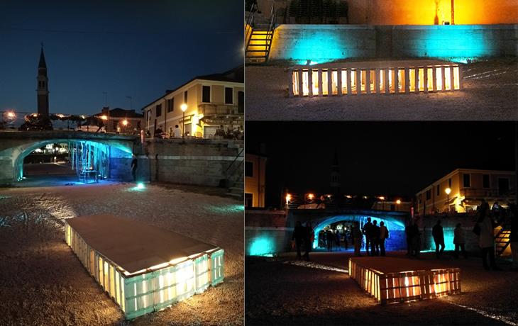 Three views of the installation: the canal and bell tower at night, the lit form beside a wall by day, and the plaza at night with people gathered around it.